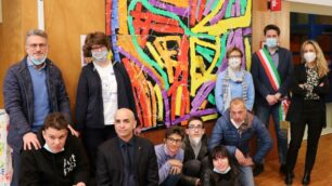 Un gruppo di ragazzi autistici delle associazioni Anffas e FacciaVista di Seregno davanti ad una delle loro opere presenti nella civica biblioteca di Seregno
