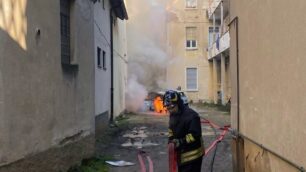 I vigili del fuoco a Sovico, sullo sfondo le auto in fiamme