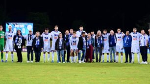 Giocatori della Folgore Caratese in campo con alcuni nonni